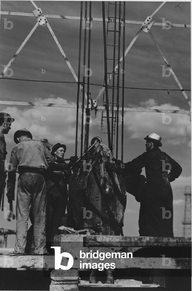Lowering a Pulley at an Oilfield, 1935-36 (b/w photo)