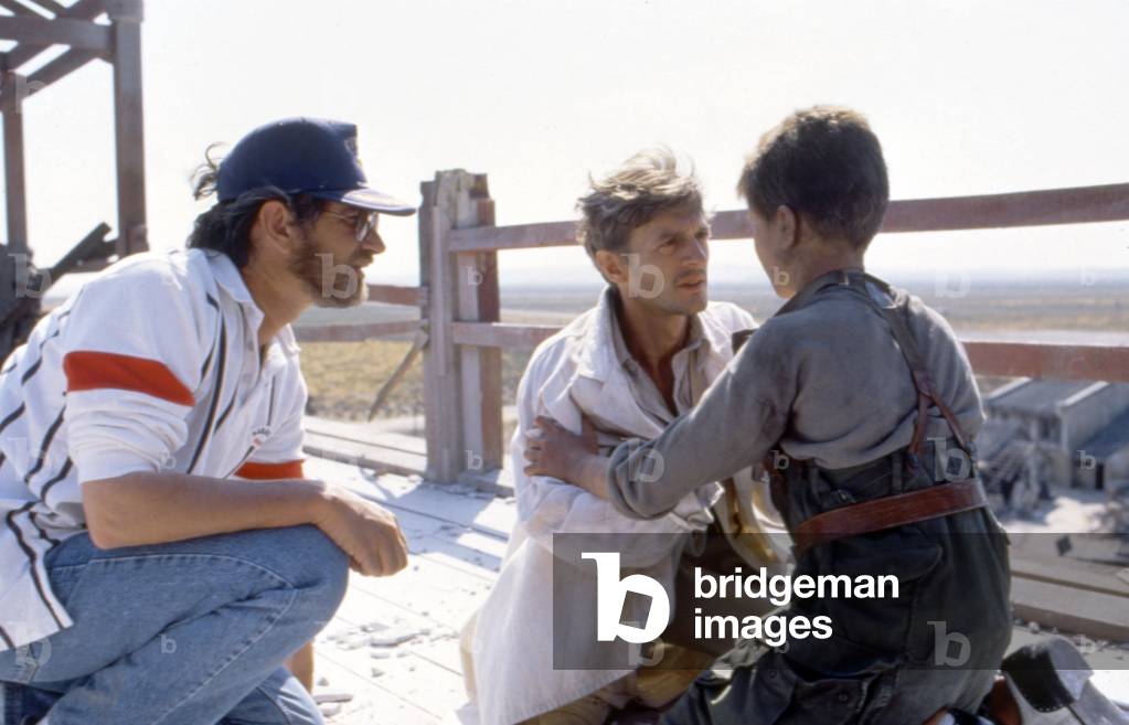 Le realisateur Steven Spielberg with Nigel Havers and Christian Bale sur le tournage du film Empire du soleil, 1987 --- Director Steven Spielberg with Nigel Havers and Christian Bale. on set of film Empire of Sun, 1987 (photo)