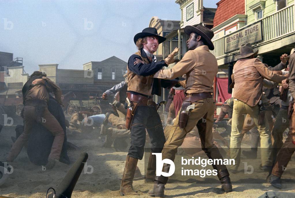 Full Shot Of Gene Wilder As Jim And Cleavon Little As Bart, Wearing Hats, Standing In Street While Cowboys Fight. Note: Boom Microphone Visible At Bottom Left., Blazing Saddles 1974 Directed By Mel Brooks