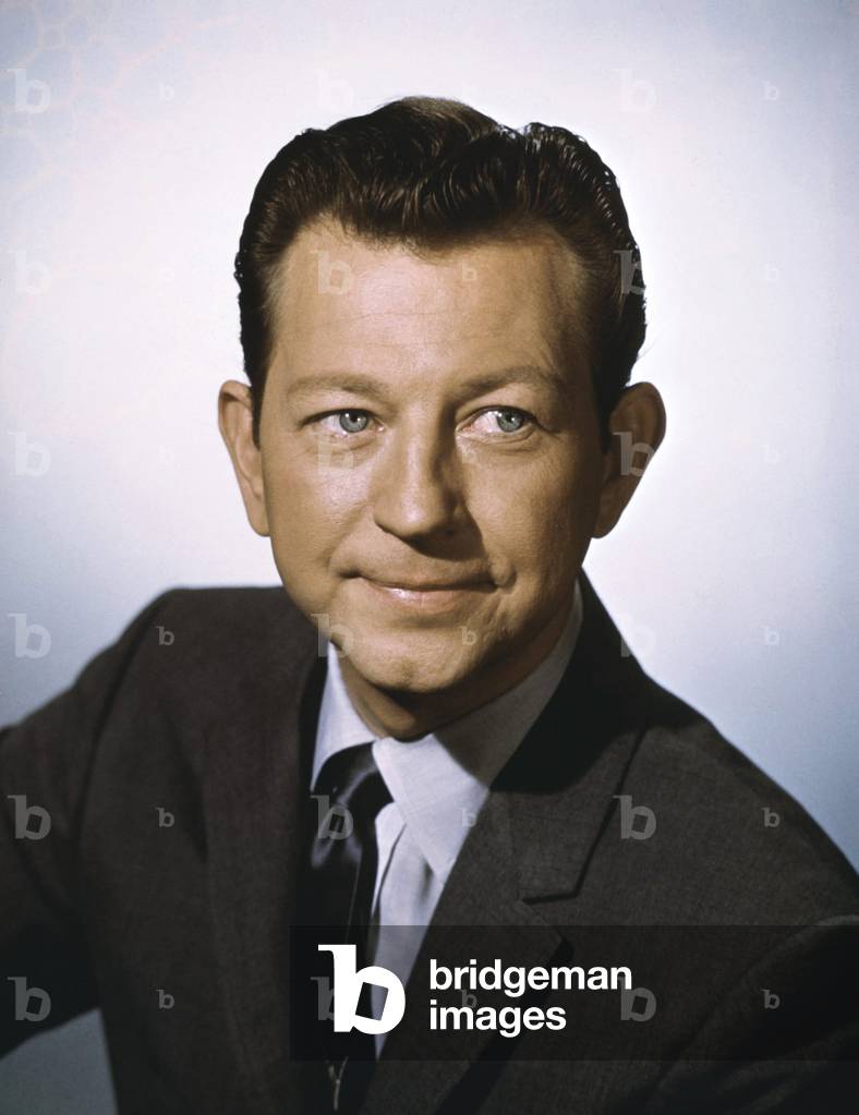Head And Shoulders Portrait Of Actor Donald O'Connor. He Is Shown Wearing A Maroon Suit And Tie.