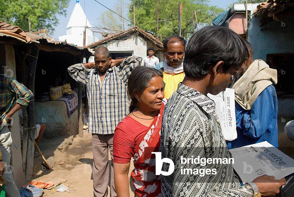 People reading a newspaper, Uttar Pradesh, India (photo)