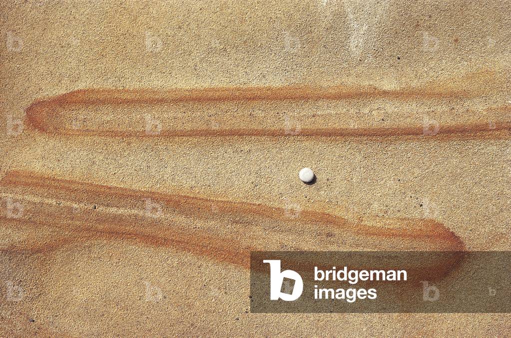 Embossed brown fingers on rock with pebble (photo)
