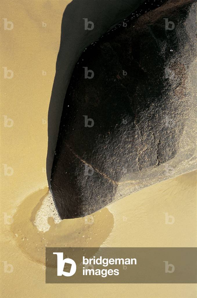 Unusual rock formation pointing a puddle on sand Vishakapatnam (photo)