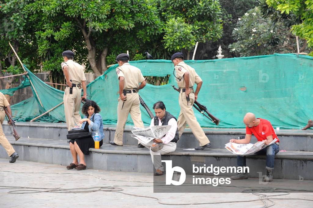People reading a newspaper outside the Taj Mahal hotel, after terrorist attack by Deccan Mujahedeen, Mumbai, 26th November 2008 (photo)