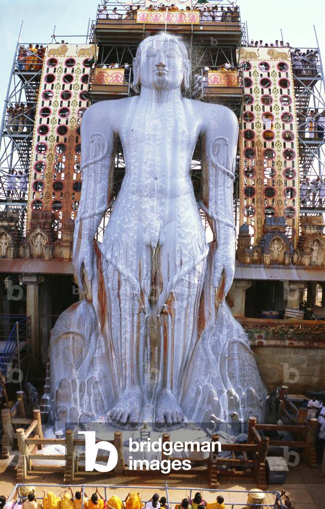 Jain devoteed pouring milk on the statue of the Bhagavan Gomateshvara