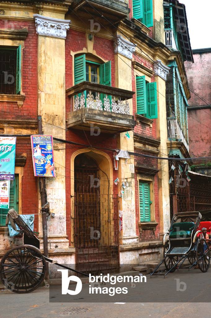 Hand rickshaws parked in front of old house, Kolkata, India (photo)