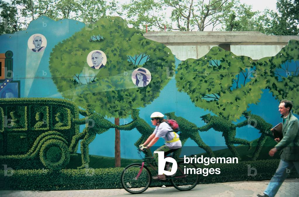 Cyclist speeding past wall painted with comic tableau , Singapore (photo)