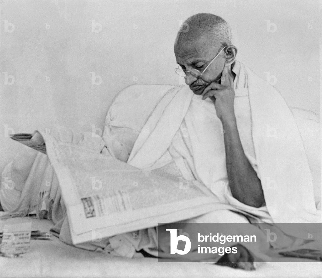 Mahatma Gandhi reading a newspaper, 1946 (photo)