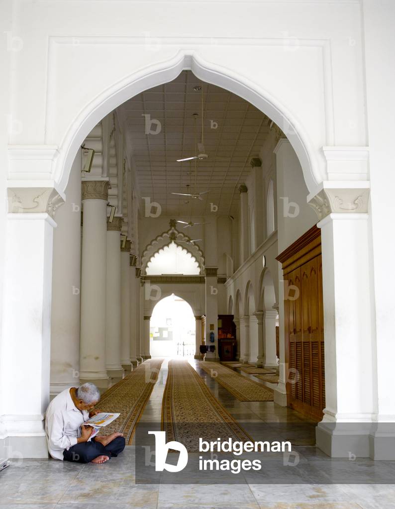 A Man reading the Newspaper At the Kapitan Keling Mosque, George Town Penang Malaysia (photo)