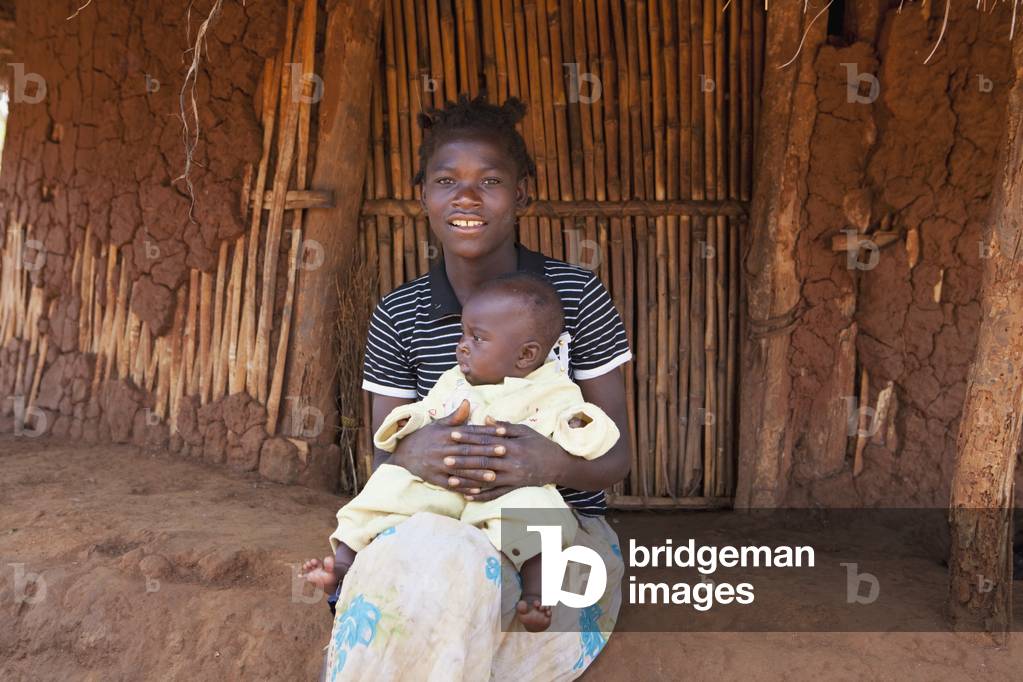 A Woman Holding her Baby outside a House, Manica, Mozambique, Africa (photo)