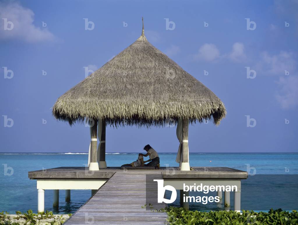 Person receiving massage on Pier with Grass Hut, The Maldives (photo)