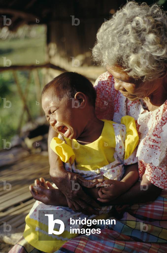 Grandmother Holding Distraught Grandaughter, Ura, Bhutan (photo)