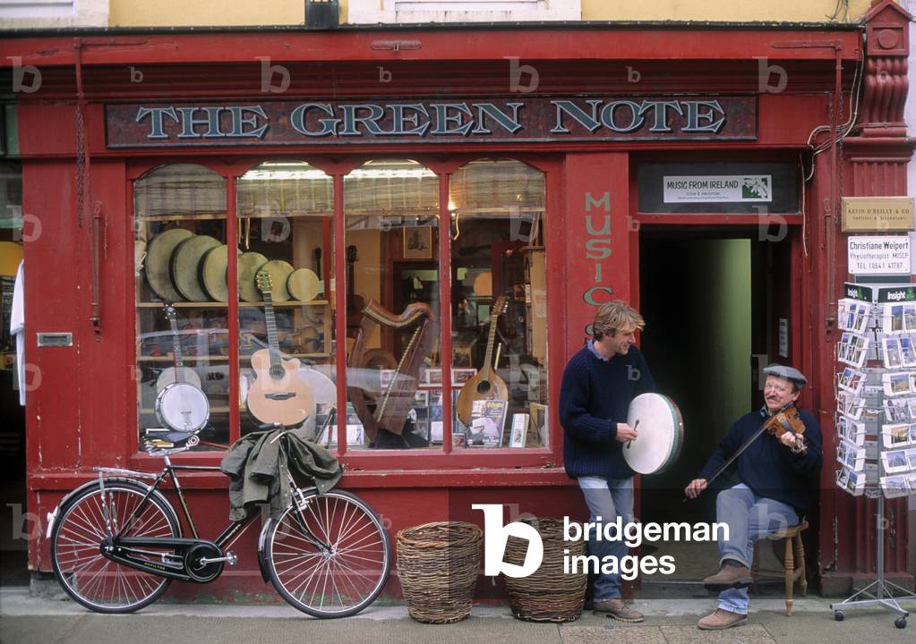 Two Men Playing A Drum And A Guitar In Front Of A Store, County Down, Republic Of Ireland (photo)