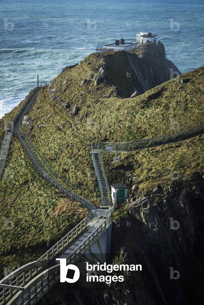 Steps leading to a building on the edge of the cliff overlooking the ocean; County Cork, Ireland (photo)