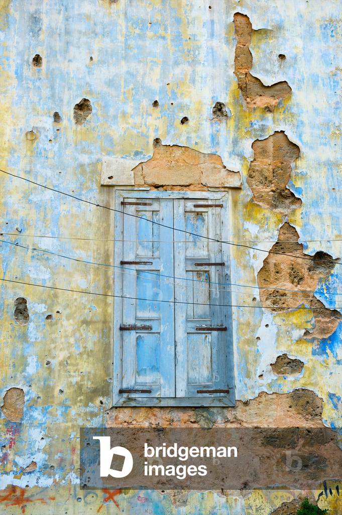Worn wooden shutters on a cracked and dilapidated building, Beirut, Lebanon (photo)