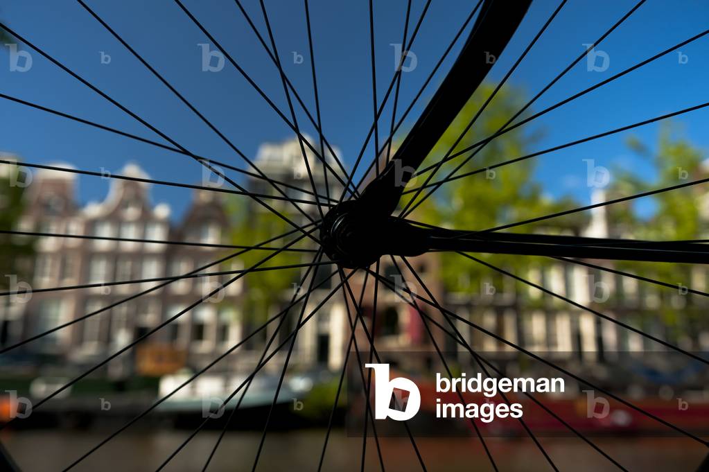 Silhouette of bicycle wheel in front of canal and traditional gabled houses, Amsterdam, Holland (photo)