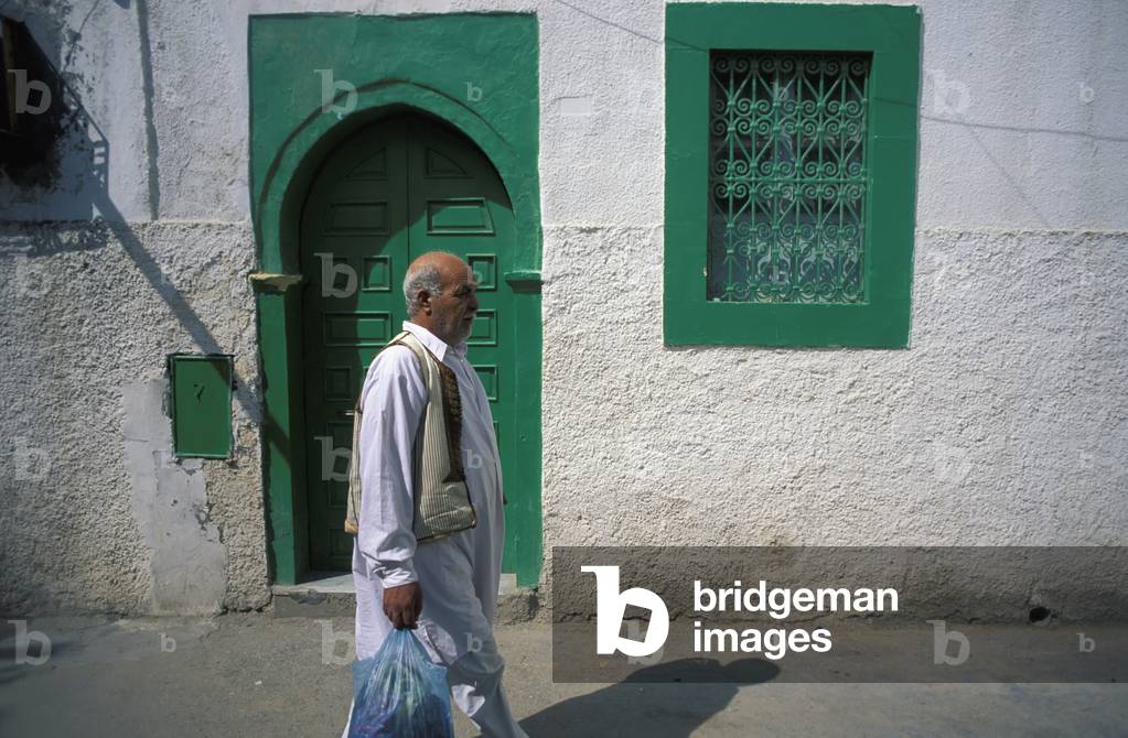 Man on Street, Walking Past Green Door (photo)
