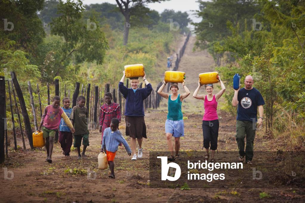 A Group of People carrying Water Jugs Up the Road, Manica, Mozambique, Africa (photo)