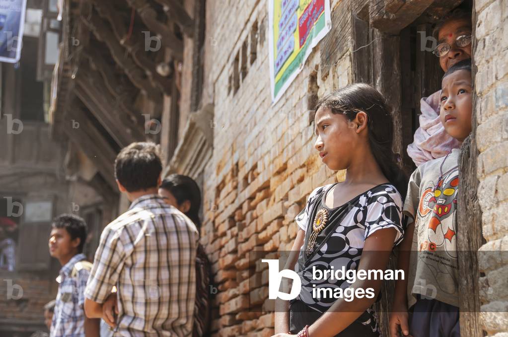 A family watching the festivities at the traditional Bisket Jatra Festival in Napalese New Year, Bhaktapur, Nepal (photo)