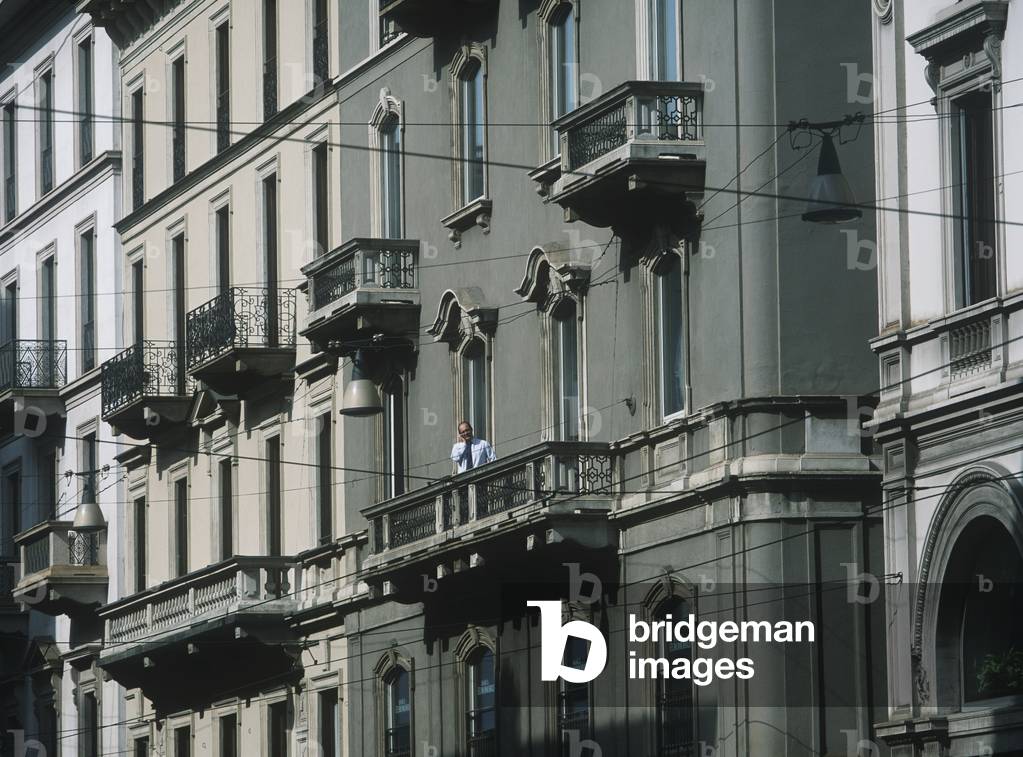 Man on Mobile Phone on Balcony of Office, Milan, Italy (photo)