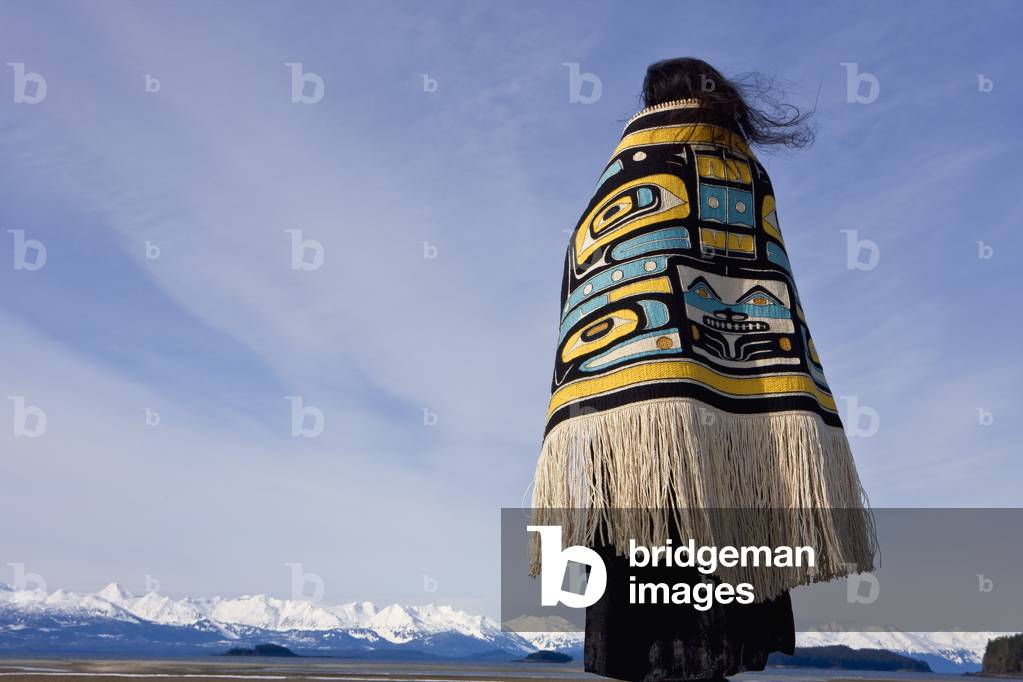 Native Alaskan Wearing A Chilkat Blanket While Looking Upward At A Soaring Bald Eagle In Alaska, Composite (photo)