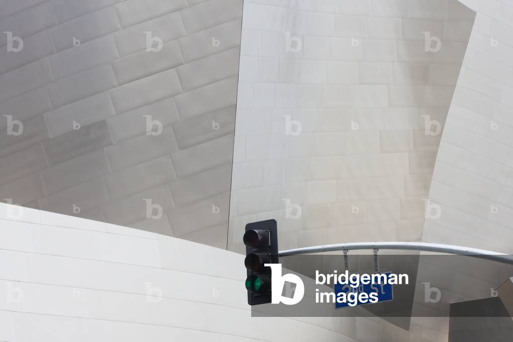 A streetlight and road sign beside a modern building, California, USA (photo)