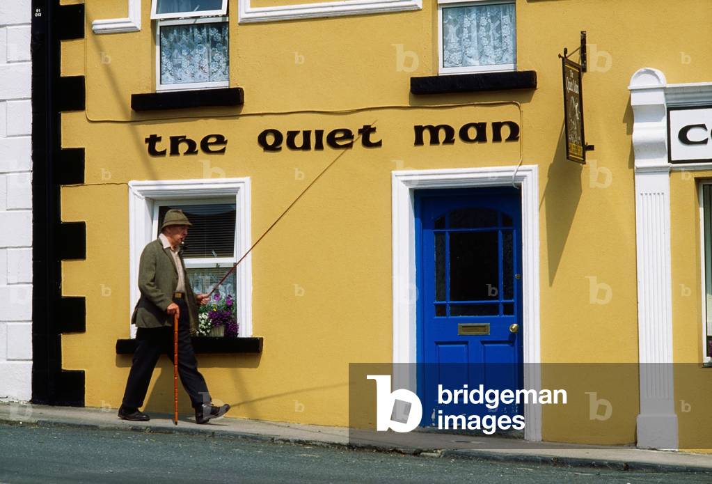 Cong, Co Mayo, Ireland; Man Walking Past A Traditional Pub (photo)