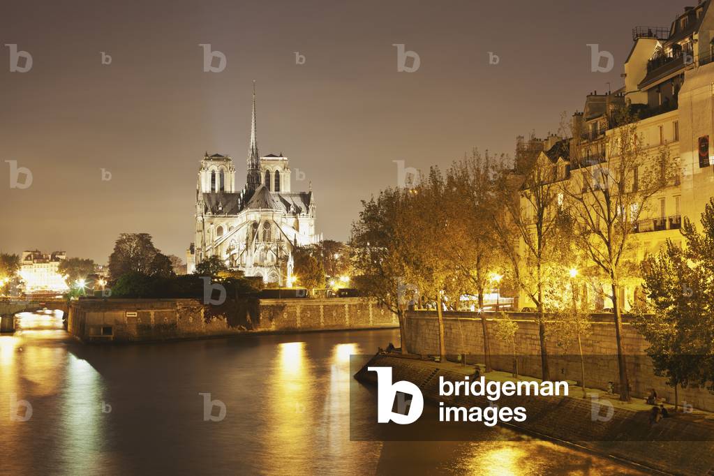 Lights illuminate the river with an illuminated church in the background, Paris, France (photo)