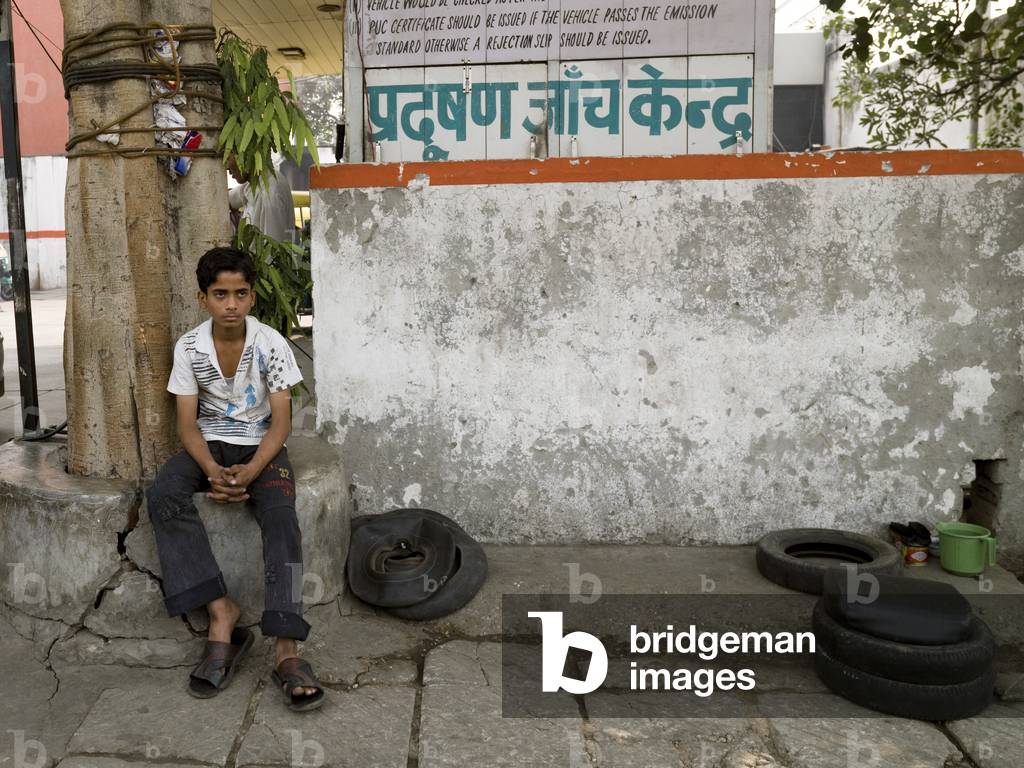 Delhi, India, Portrait of a Boy sitting outside Car Mechanics (photo)