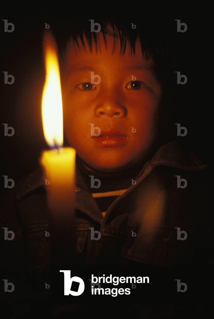 Young Child behind Lit Candle, Kathmandu, Nepal (photo)
