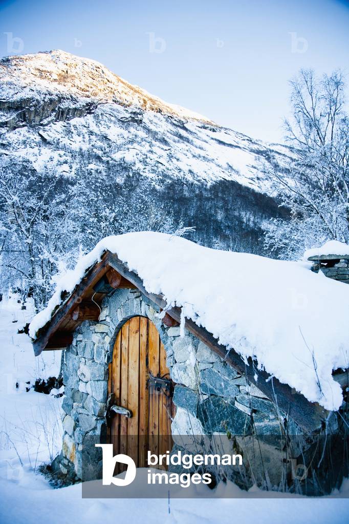 Norway, Sognefjord, snow covered traditional stone building which houses hydro electric generator, Ortnevik, Snowy alpine scenery (photo)