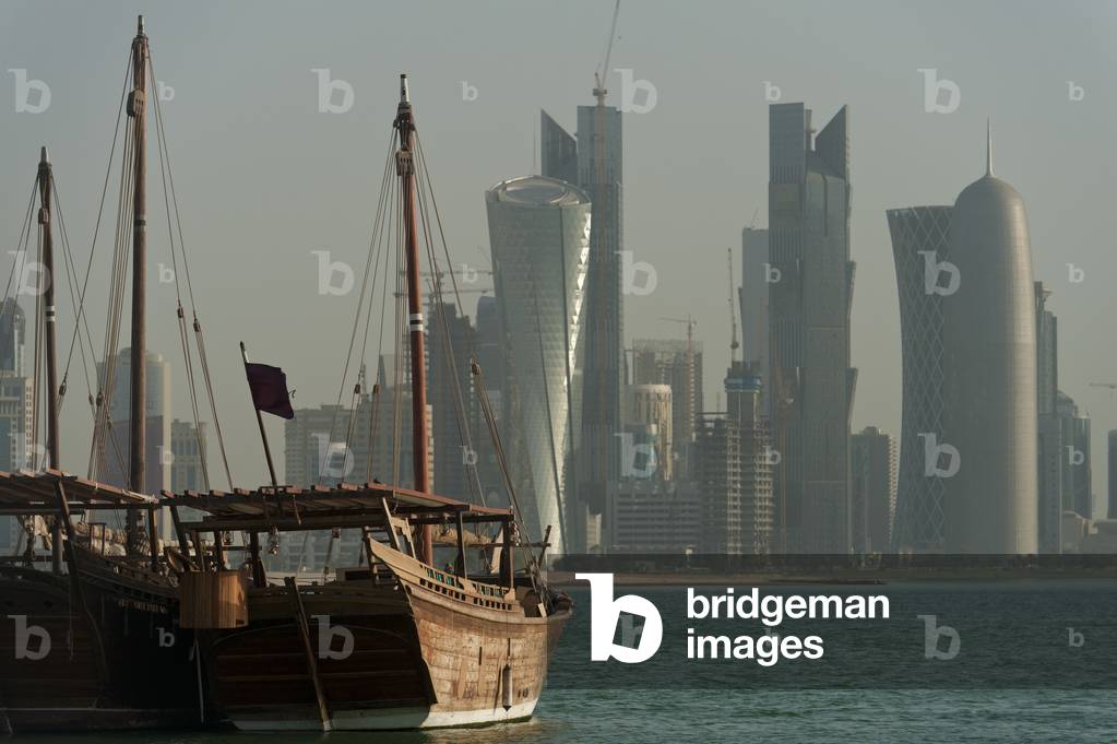 Wooden boats in the harbour with the modern skyline of Doha behind, Doha, Qatar (photo)