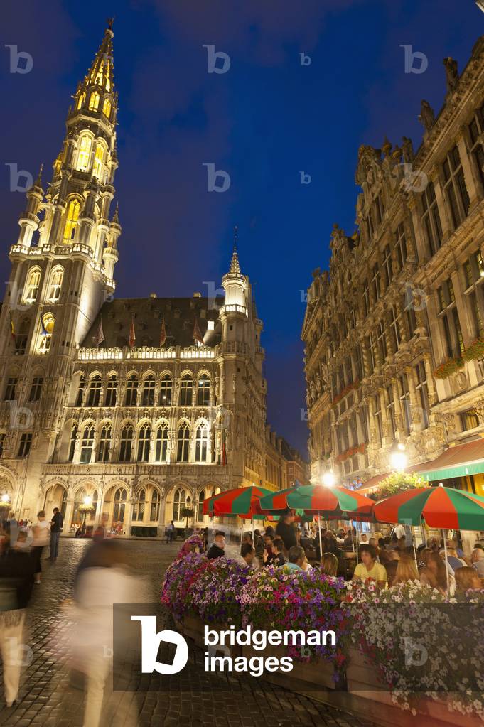 Belgium, People eating and drinking at cafe tables at dusk in Grand Place, Brussels (photo)