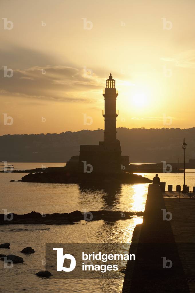 Greece, Crete, Silhouette of lighthouse at harbor entrance at dawn, Chania (photo)