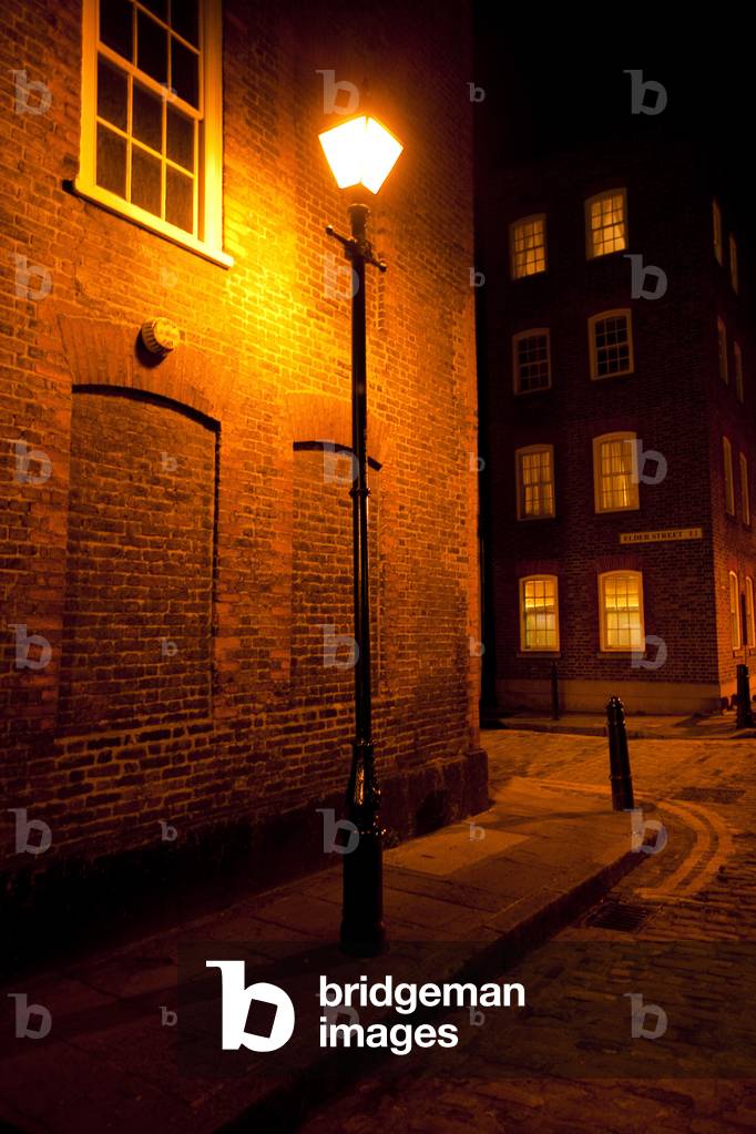 Victorian street lamp lights streets of East London at night, London, England (photo)
