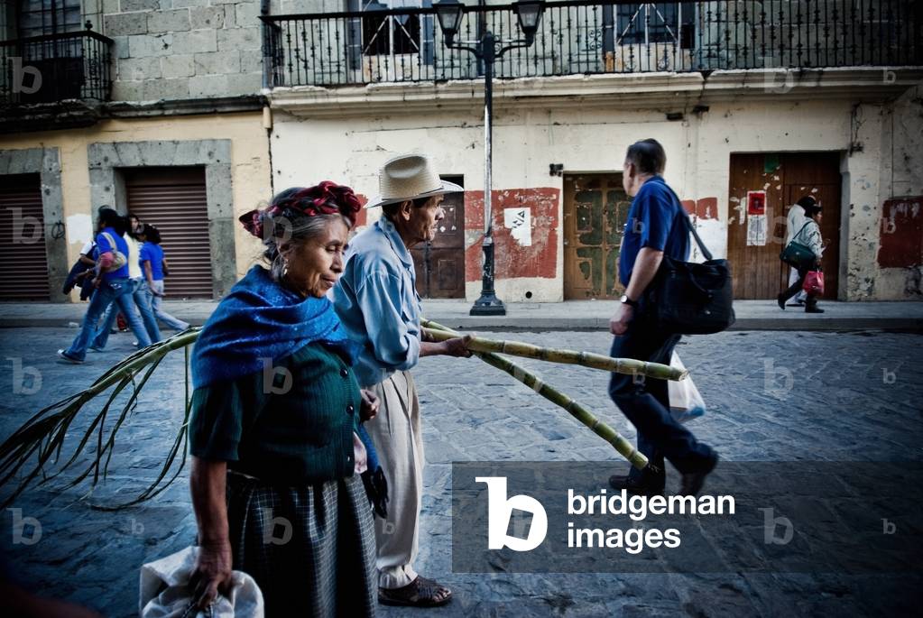 Man and Wife on Urban Street carrying Fresh Sugar Cane, Mexico (photo)