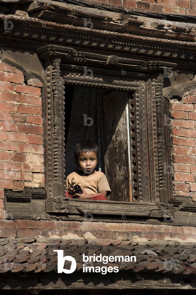 Young Child looking out of Window, Ancient City of Bhaktapur, Nepal (photo)
