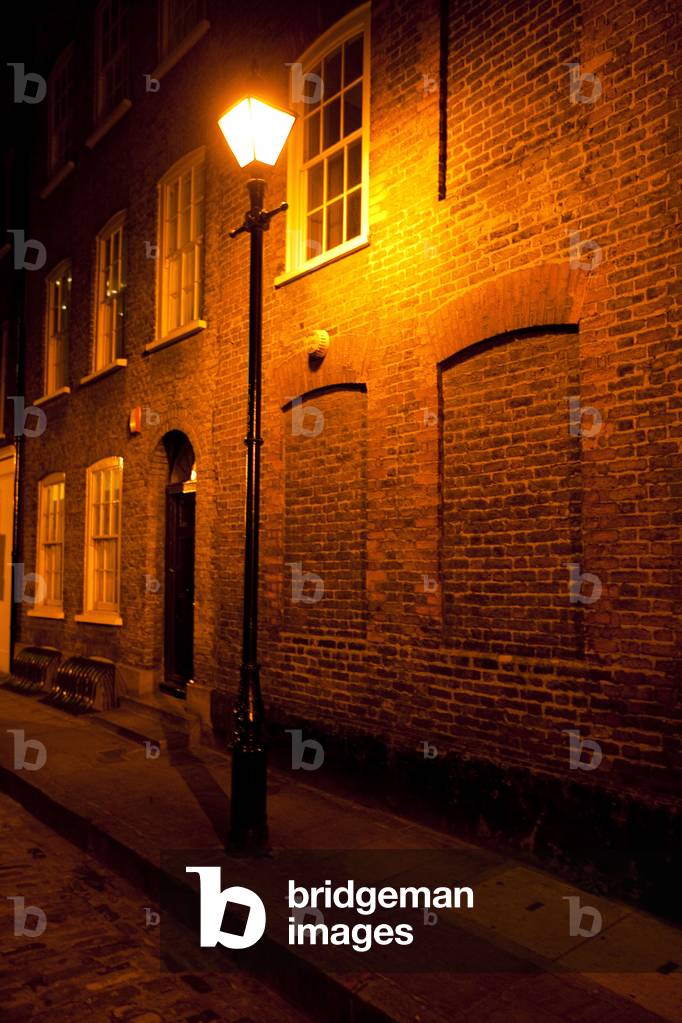 Victorian street lamp lights streets of East London at night, London, England (photo)
