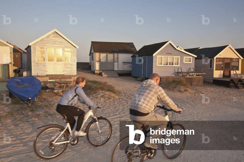 People Riding Mountain Bicycles on Beach Near Beach Huts, Christchurch Harbour, Mudeford, Dorset, England, UK , United Kingdom (photo)