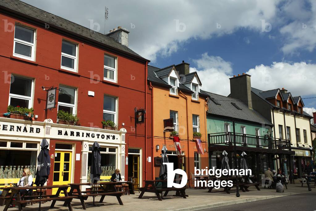 Colourful buildings and picnic tables along the street; Glengarriff, County Cork, Ireland (photo)