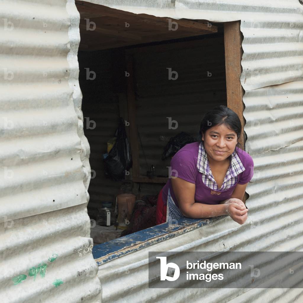 A Young Woman Leans out a Window, Guatemala City Guatemala (photo)