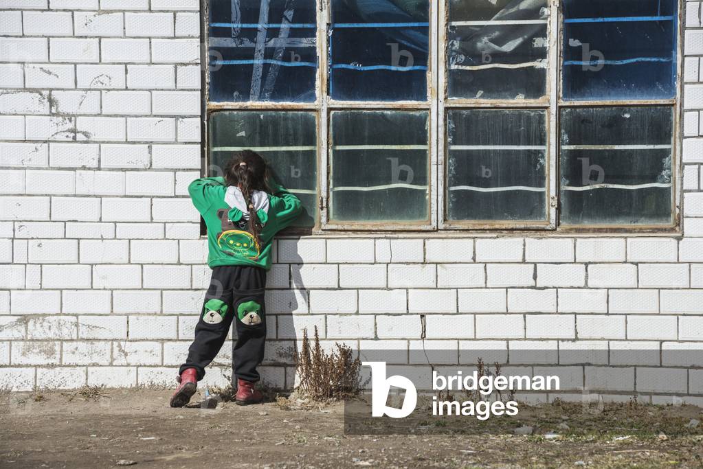 Young girl looking through the window, Qingzhenxiang, Tibet (photo)