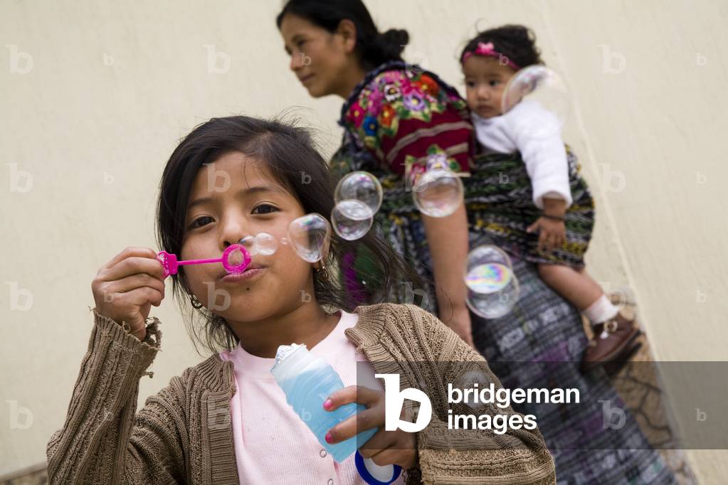 Girl Blowing Bubbles with a Bubble Wand, Patzicia, Guatemala (photo)