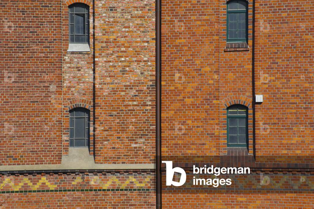 Facade of a brick building with windows and a patterned stripe, Hamburg, Germany (photo)