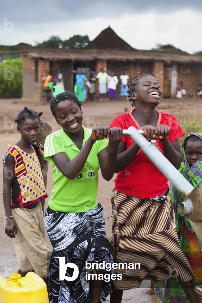 A Group of Girls Pumping Water At a Well, Manica, Mozambique, Africa (photo)