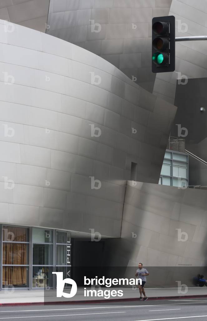 A jogger runs on a road beside a modern building, California, USA (photo)