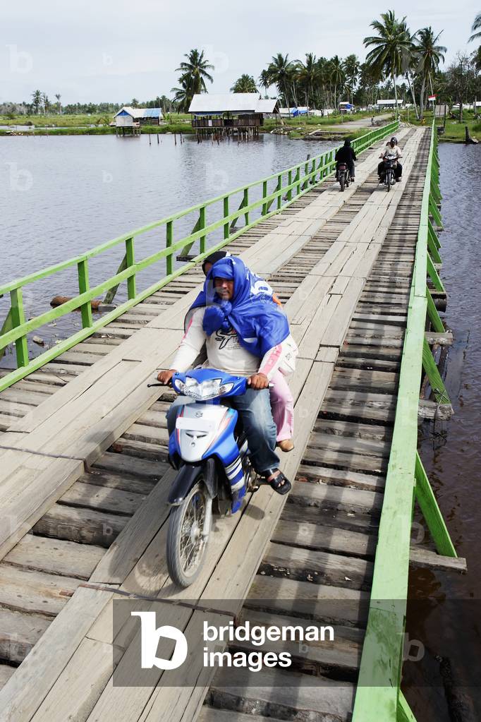Motorbike crossing a temporary bridge made of wood after the Indian Ocean tsunami in 2004, Sumatra, Indonesia (photo)