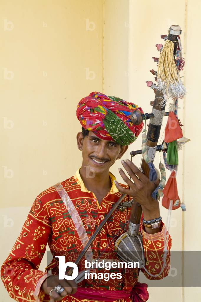 Young Man in Traditional Costume Playing Instrument Called a Sarangi, Agra, India (photo)