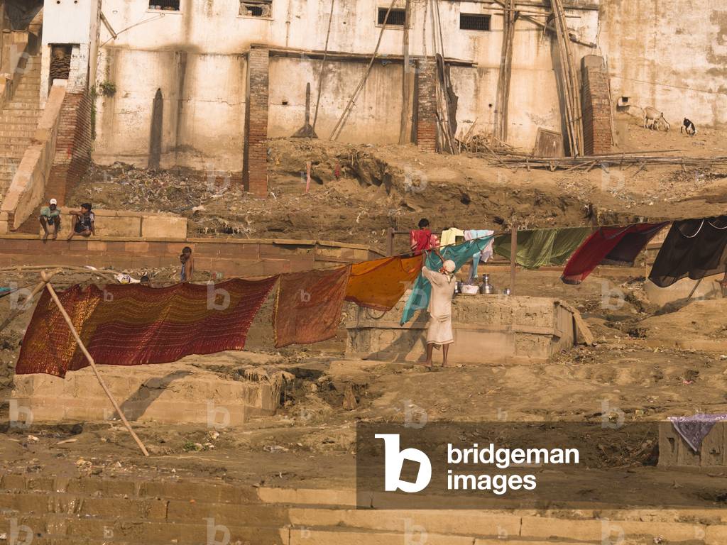 Woman hanging her Saris to Dry on the Ghats by the River, the Ganges, Varanasi, India (photo)