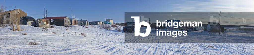 Snowmobile tracks run between houses and power lines in the village of Noatak, Arctic Alaska, USA, Winter (photo)
